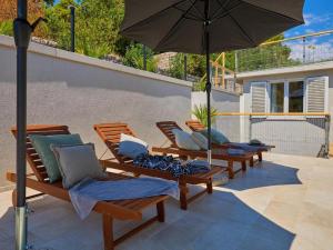 a group of chairs and an umbrella on a patio at Palm Tree Apartments in Dubrovnik
