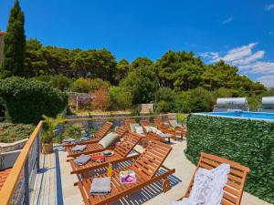 una fila di sedie a sdraio accanto alla piscina di Palm Tree Apartments a Dubrovnik