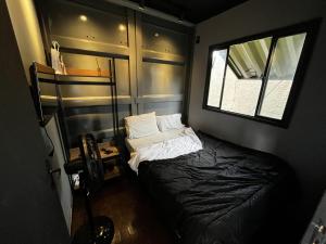 a small room with a bed and a window at Container-Spa quente, projetor cine, lareira, churrasqueira-20km de Brotas in Torrinha