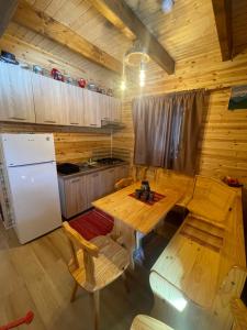 een keuken met een tafel en stoelen en een koelkast bij Aroa Mountain in Zărneşti