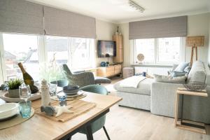 uma sala de estar com um sofá e uma mesa em Rising Sun Westende em Middelkerke