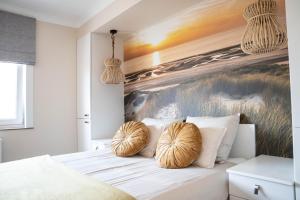 een slaapkamer met een wit bed met 2 kussens bij Rising Sun Westende in Middelkerke