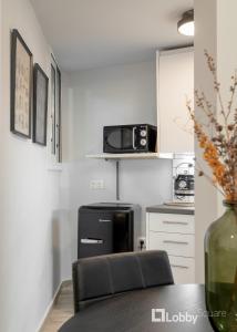 Il comprend une cuisine équipée d'un réfrigérateur noir et d'une table. dans l'établissement CityLiv Apartment by LobbySquare, à Athènes