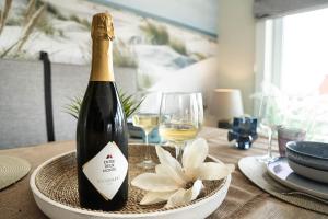 a bottle of wine on a table with a flower at Rising Sun Westende in Middelkerke