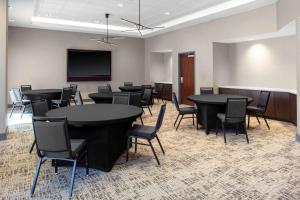 a conference room with tables and chairs and a tv at Hyatt House Charlotte Rea Farms in Charlotte
