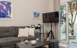 - un salon avec un canapé et une télévision dans l'établissement CityLiv Apartment by LobbySquare, à Athènes