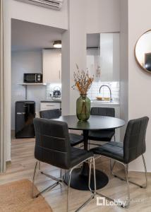 une salle à manger avec une table et des chaises noires dans l'établissement CityLiv Apartment by LobbySquare, à Athènes