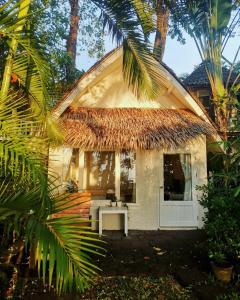 Cabaña con techo de paja y puerta blanca en Saffron On The Sea Resort, en Ko Chang