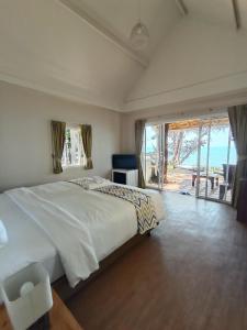 a bedroom with a large bed and a large window at Saffron On The Sea Resort in Ko Chang