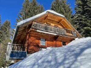 a log cabin with a balcony in the snow at Axterhütte 