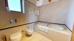 a bathroom with a tub and a toilet and a sink at Augubio Penthouse in Split