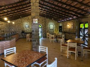 a restaurant with tables and chairs in a room at Green Pastures - A Hill Country Resort in Kodaikānāl