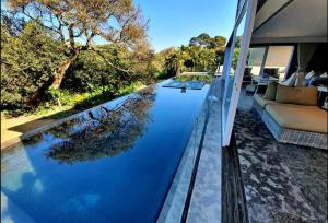 a swimming pool in the middle of a house at Splash Rock Beachfront Villa in Umtentweni