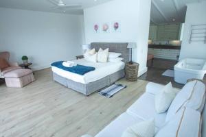 a living room with a bed and a couch at Splash Rock Beachfront Villa in Umtentweni