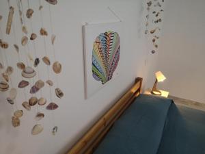 um quarto com uma cama e uma imagem e conchas na parede em Da Noi em Vico del Gargano