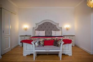 a bedroom with a large white bed with red sheets at Vila Rozalia Garden Gate in Avrig