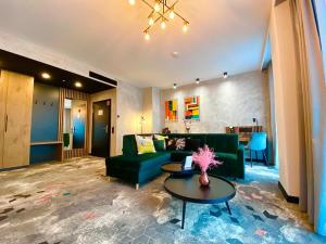 a living room with a green couch and a table at Focus Hotel Premium Bydgoszcz in Bydgoszcz