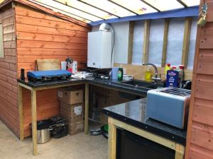 a kitchen with a counter with a stove and a sink at Cox Hill Glamping Badger in Truro