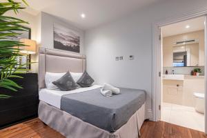 a small bedroom with a bed and a bathroom at The Great London Apartments in London