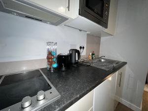 a kitchen counter with a sink and a microwave at Moorfield Liverpool City Studios in Liverpool
