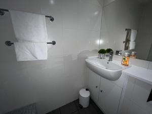 La salle de bains blanche est pourvue d'un lavabo et de toilettes. dans l'établissement Moorfield Liverpool City Studios, à Liverpool