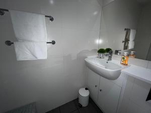 a white bathroom with a sink and a toilet at Moorfield Liverpool City Studios in Liverpool