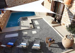 an overhead view of a pool with chairs and an umbrella at LaCasa 1 Deluxe Villa with Pool and Jacuzzi in Roumelí