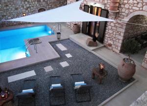 an overhead view of a pool with chairs and a white umbrella at LaCasa 1 Deluxe Villa with Pool and Jacuzzi in Roumelí