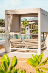 a gazebo by the pool at a resort at ERTH Abu Dhabi Hotel in Abu Dhabi