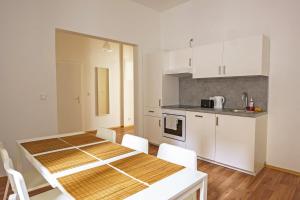 eine Küche und ein Esszimmer mit einem Tisch und Stühlen in der Unterkunft Vienna Living Apartments - Müllnergasse in Wien