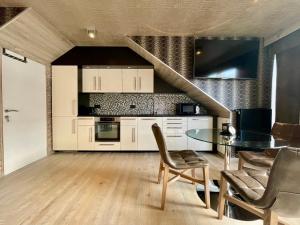 uma cozinha com uma mesa e cadeiras e uma escadaria em Guesthouse ROOM40 em Malmedy