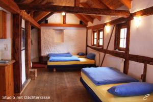 three beds in a room with wooden beams at Bio-Ferienwohnung Ellensohn in Lindau