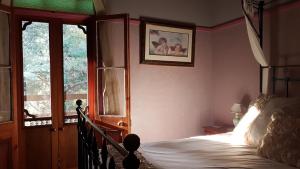 Freida - Historic Farmhouse Bellingen في Gleniffer: غرفة نوم بسرير ونافذة كبيرة