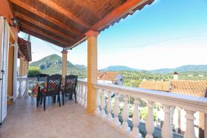 a balcony with chairs and a table with a view at Platouka's House in Ágios Matthaíos