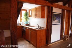una cocina con armarios de madera y fregadero en Bio-Ferienwohnung Ellensohn, en Lindau