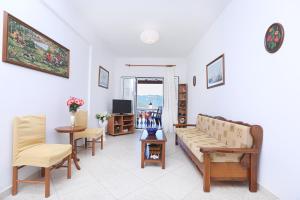 sala de estar con sofá, sillas y TV en Platouka's House en Ágios Matthaíos