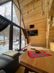 a room with a table in a wooden cabin at Aroa Mountain 4 in Zărneşti