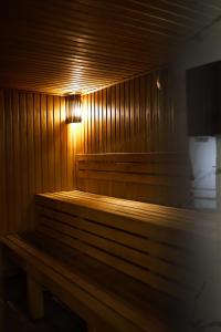 una panca di legno in una stanza con una luce sopra di Continental a Bukovel