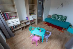 薩拉濟的住宿－Meublé de tourisme " Le Jasmin Étoilé"- Hell-Bourg - SALAZIE，客厅配有蓝色桌子和2把粉红色椅子