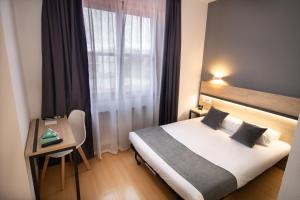a hotel room with a bed and a table and a window at Alda Puerto Seco in Burgos +33 photos