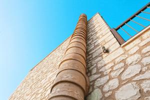 a tall brick building with a blue sky in the background at LaCasa 1 Deluxe Villa with Pool and Jacuzzi in Roumelí
