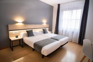 a hotel room with a large bed and a window at Alda Puerto Seco in Burgos