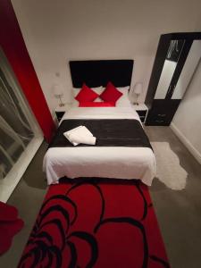a bedroom with a large bed with red pillows at Comfy Stay and Relaxing Apart in London