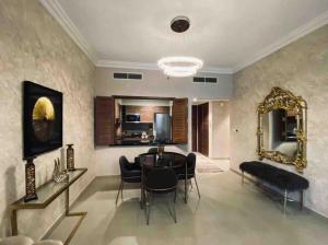 a dining room with a table and chairs and a mirror at Luxurious 1 bed Apt with Outdoor Patio - Madinat Badr in Dubai