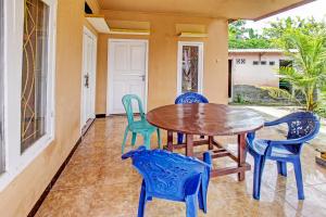 comedor con mesa y sillas en el porche en OYO 92197 Zahira Homestay, en Ekas