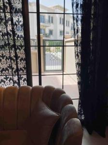 a couch in a living room with a large window at Luxurious 1 bed Apt with Outdoor Patio - Madinat Badr in Dubai