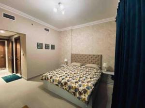 1 dormitorio con cama y cortina azul en Luxurious 1 bed Apt with Outdoor Patio - Madinat Badr, en Dubái