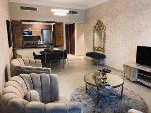 a living room with a couch and a table at Luxurious 1 bed Apt with Outdoor Patio - Madinat Badr in Dubai