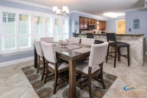 a kitchen and dining room with a wooden table and chairs at SO 101 - Large 3 BR Beachfront Ground Floor Condo in Fort Walton Beach