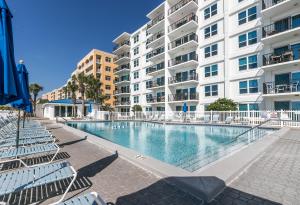 a swimming pool in front of a large apartment building at SO 101 - Large 3 BR Beachfront Ground Floor Condo in Fort Walton Beach